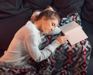 Woman sleeping while studying messing up her sleep pattern.