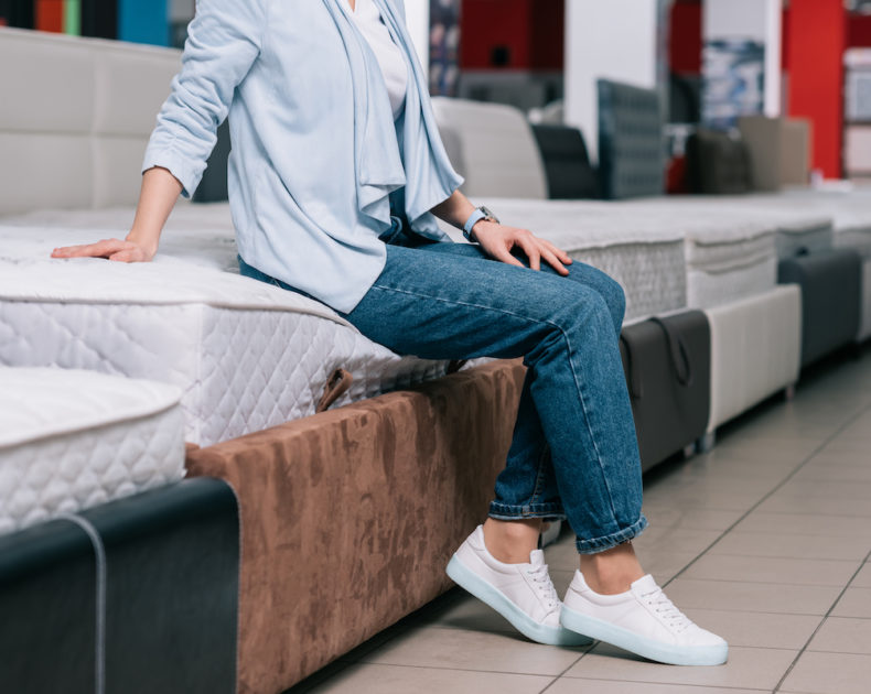 Woman testing the temp of a bed