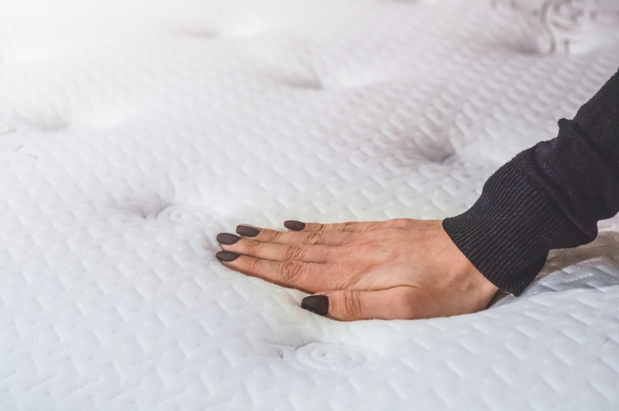 Girl touches the mattress. Mattress buying guides.