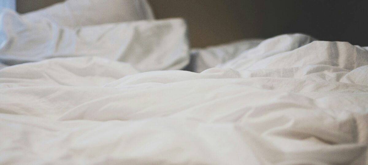 A mattress with blankets and a pillow