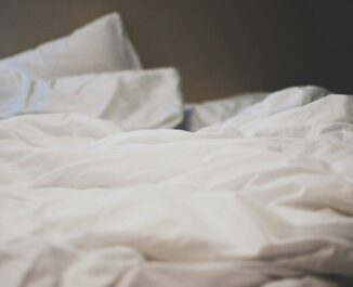 A mattress with blankets and a pillow